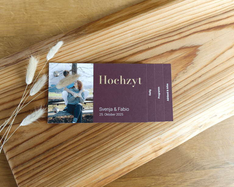 Hochzeitseinladungskarte mit einem Foto des Paares vor einem rustikalen Holzbrett-Hintergrund.