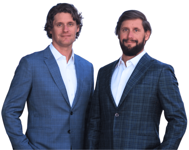 Arkansas Criminal Defense and Personal Injury Attorneys Kyle and Kale Ludwig smile; Capitol in back.