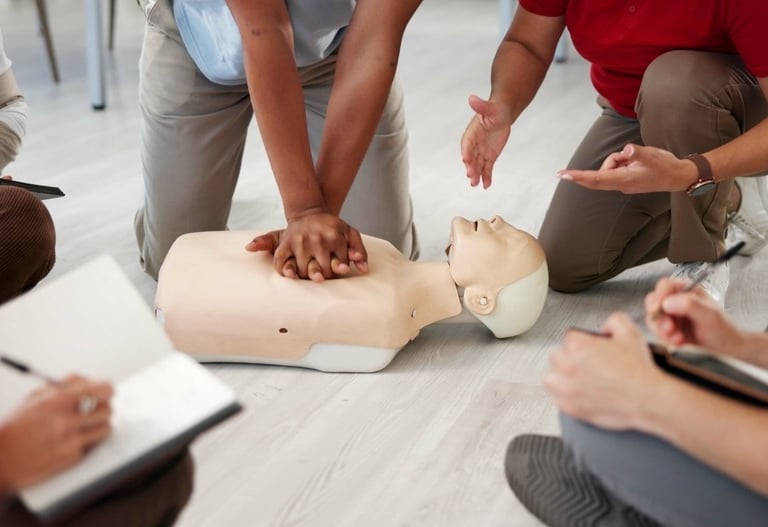 A traininer training student on administering CPR on a dummy, with other students taking notes