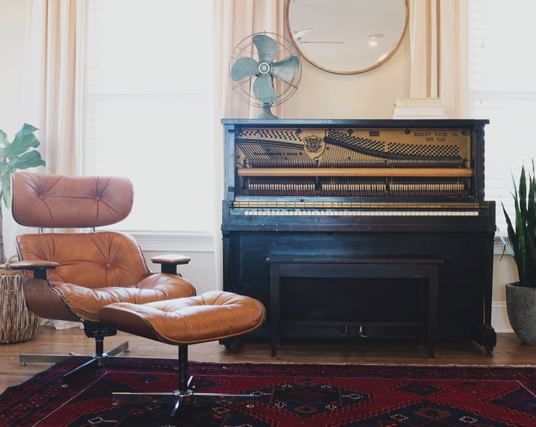 relaxing leather chair with footstool. Black piano in background with retro fan on top