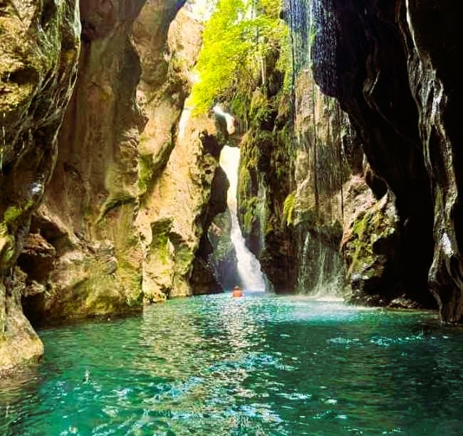 Steep cliffs of Kourtaliotiko Gorge with a river and small waterfalls