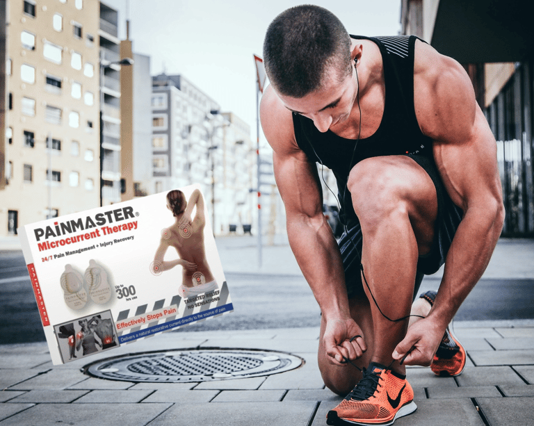 Young man runner doing his shoe laces with a painmaster box next to him.