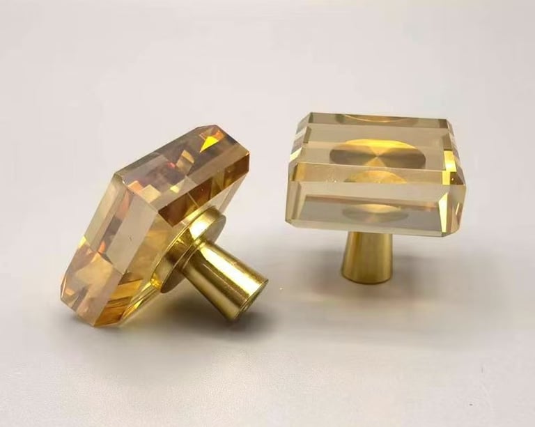 Amber square crystal cabinet knobs with brushed gold hardware for luxury home decor.