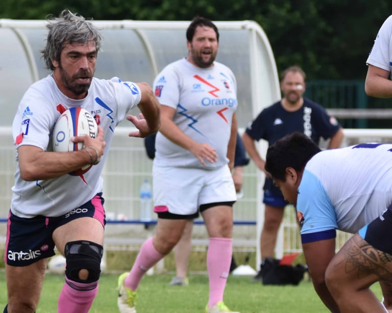 Juan con la pelota de rugby que va al contacto de uno mucho mas grande que el