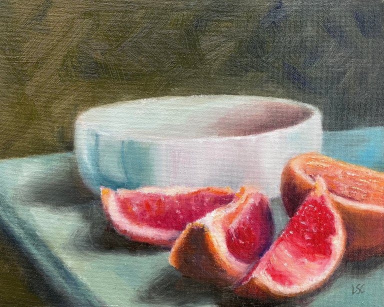 An original oil painting of a grapefruit which has been halved and sliced in front of a bowl