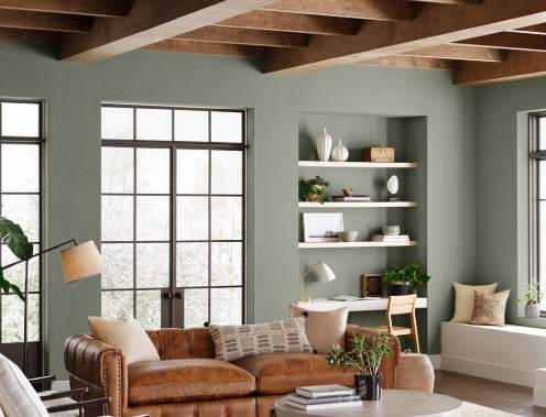Living room with exposed ceiling beams, seating, and built-in shelving.