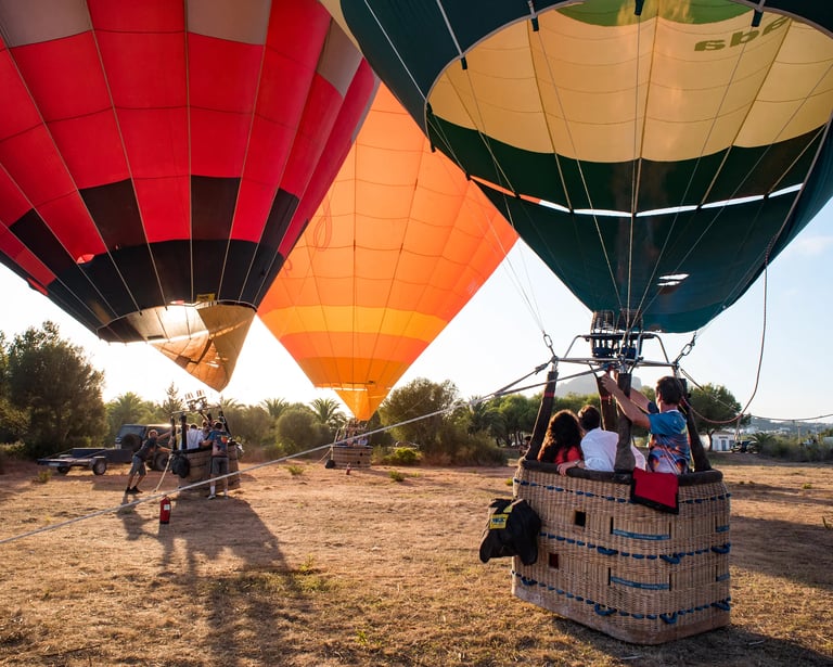 a group of people standing in a field with a hot air balloon, globos mallorca, turismo, excursión