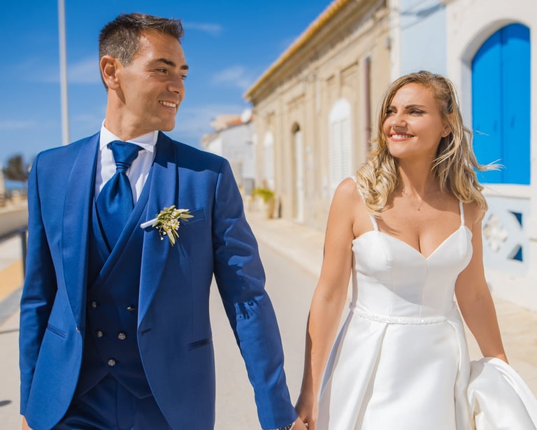 sposo e sposa che passeggiano al mare