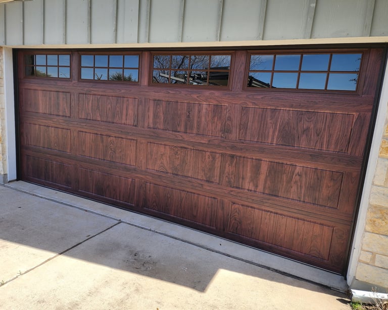 Wood grain, grooved long panel garage door with windows on top. Installed by On Point overhead Doors