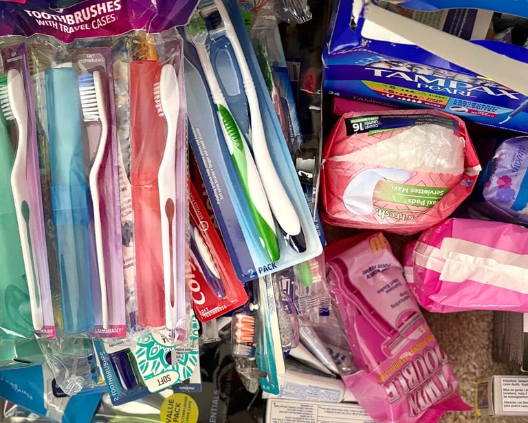 a bunch of toothbrushes and toothpaste in a pile of various hygiene products