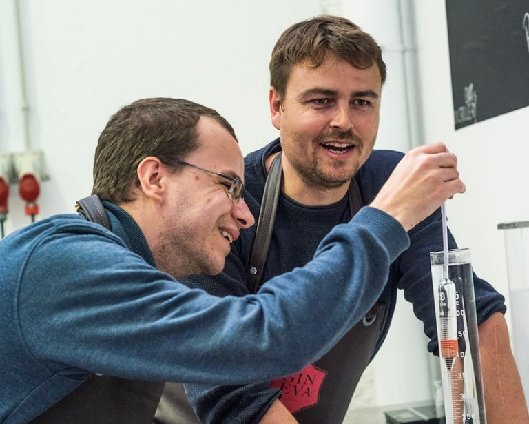two men standing in front of a chalkboard, ginebra, mallorca, ginebra artesana, marca person
