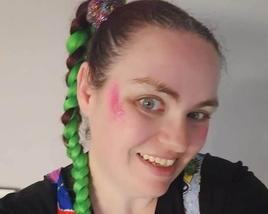 a woman with green hair and pink makeup