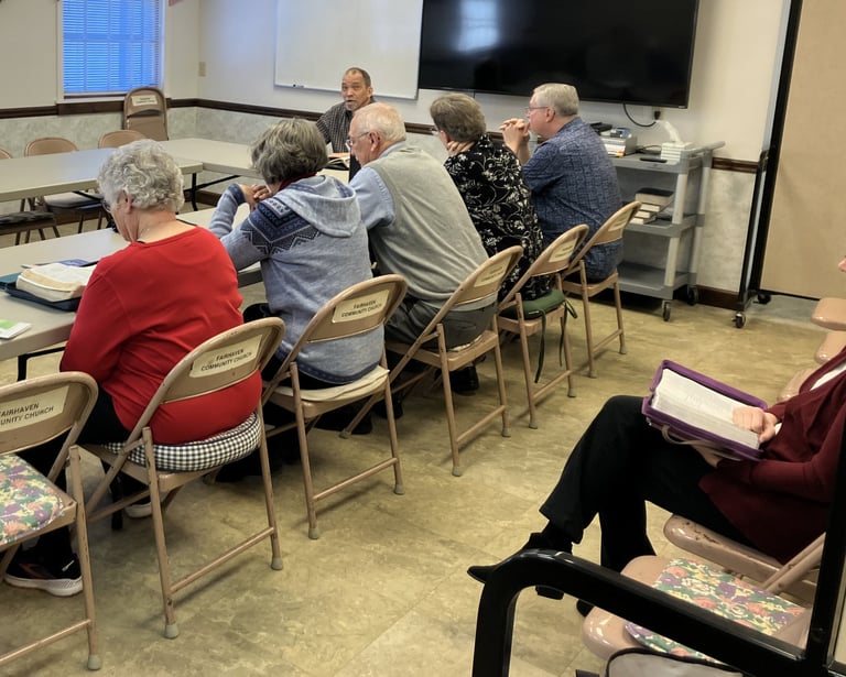 people sitting at a table studying the Bible 