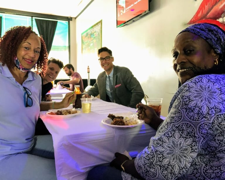 Four people in meeting around a table, smiling at the camera