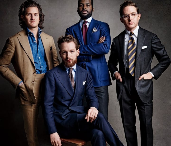 a group of men in suits and ties posing for a photo