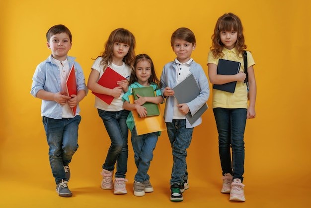 a group of children holding books and bookshelves