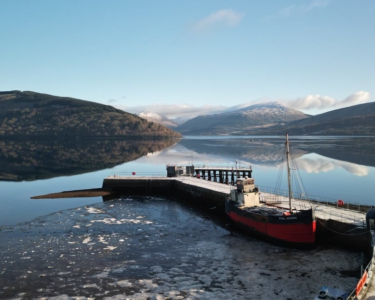 a boat docked on Loch Fyne with mountains in the background