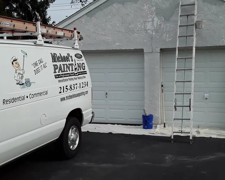 a van in a driveway with ladders on a garage