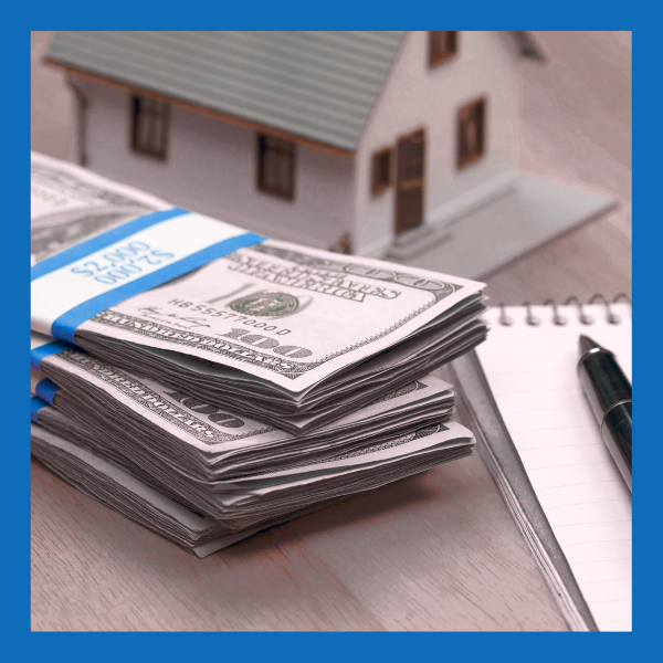 cash for your New Hampshire home; a stack of money bills and a pen and pen on a desk