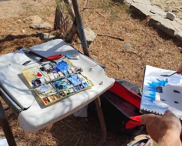 a watercolor pallett and other painting materials