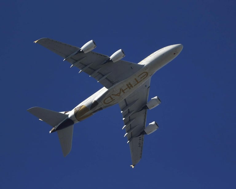 An Etihad Airways passenger airplane flying overhead in the sky