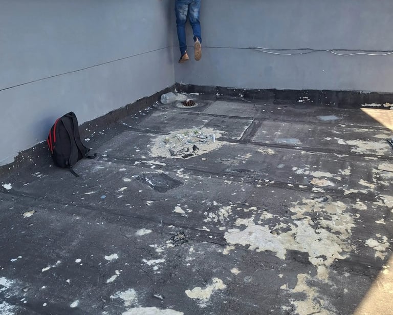 Flat roof with membrane peeling from UV exposure and thermal movement cracks
