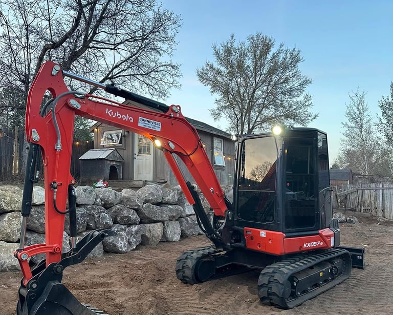 Kubota sitting idle next to completed boulder wall in Ogden, UT