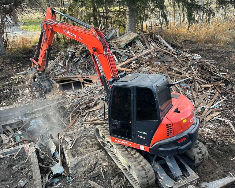 Kubota excavator demoing a residential structure