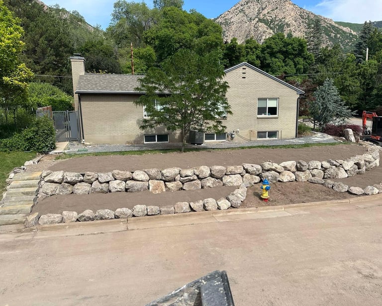 boulder wall and graded dirt at residential home