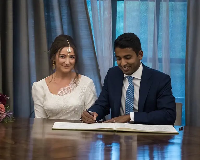 newly-weds signing the register in the westminster room at old marylebone town hall
