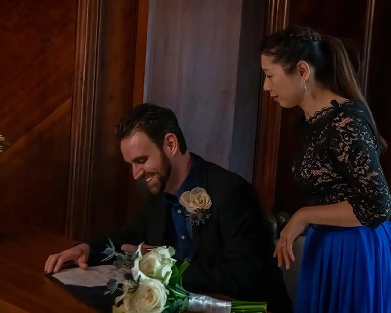 newly-weds signing the register in the marybone room at old marylebone town hall