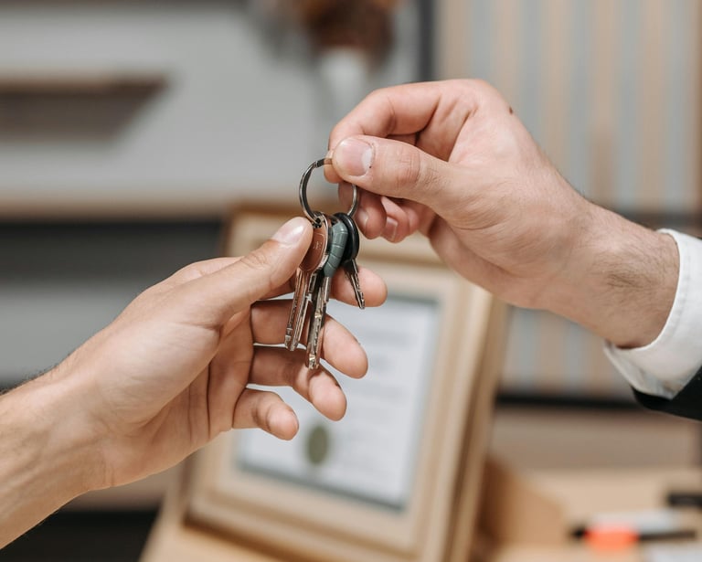 A real estate agent handing house keys to a new homeowner after a successful property sale.