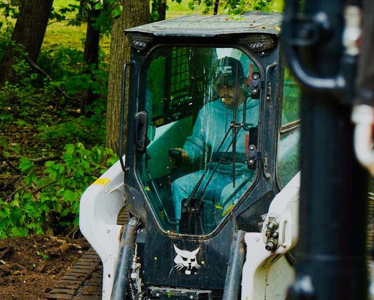 Owner, Patrick Kruse, in a bobcat skid steer grading dirt