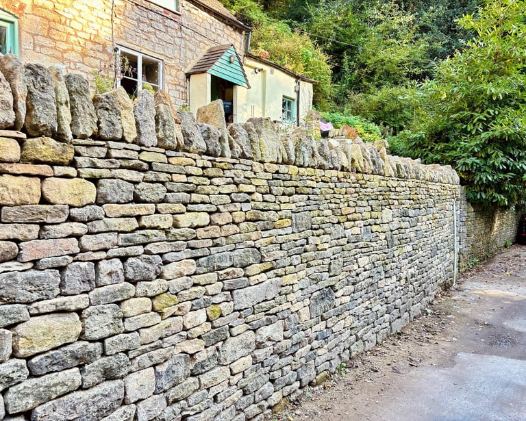A traditional dry stone retaining wall with cock and hen capping