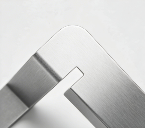 Close-up of a brushed stainless steel metal corner joint with a precision notch design.