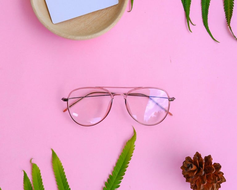 lentes transparentes sobre UN Fondo Rosa y al LADO UN como de pino con un cuenco y dentro un papel