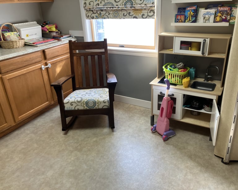 a children's nursery with toys and a rocking chair  