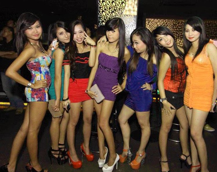 a group of young women standing in front of a bar