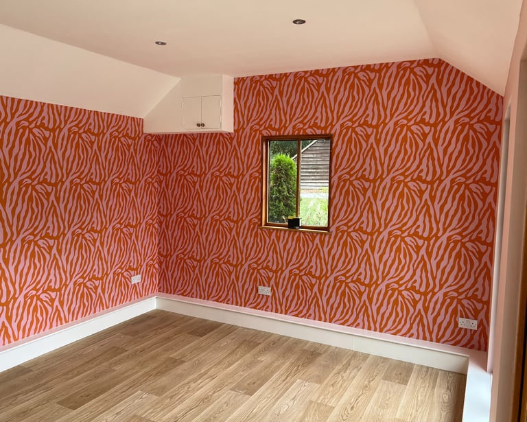 Bold red and pink zebra print wallpaper and light oak laminate flooring in Sussex.