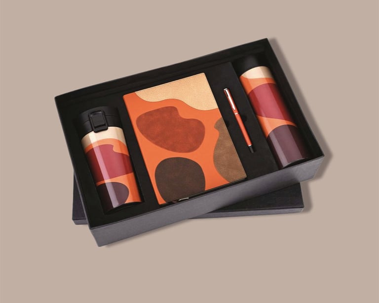 Vibrant new joinee kit with an artistic notebook, thermal flask, tumbler, and pen.