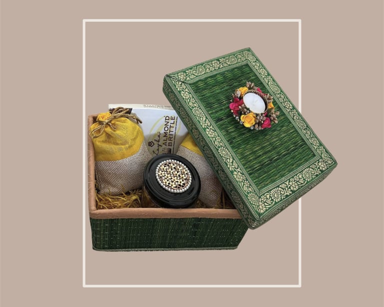 Emerald green textured gift trunk with almond brittle and festive gifting decor.