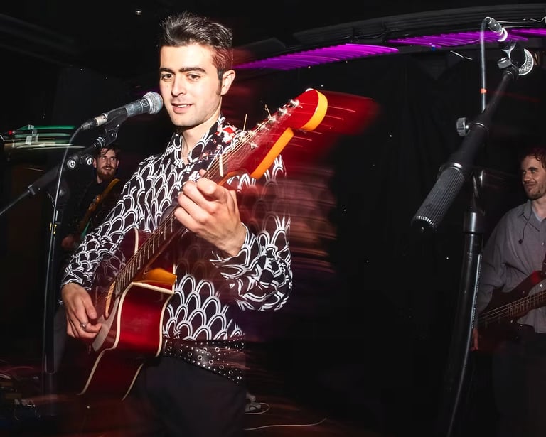 Brighton UK singer songwriter Olly Williams playing electric guitar during live show