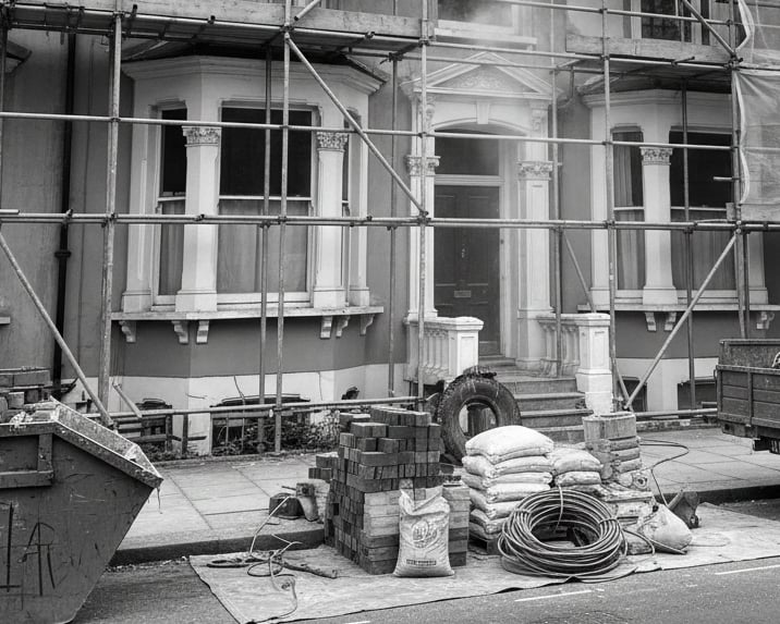 a truck parked in front of a house with scaffolding. Refurbishment externally being carried out.