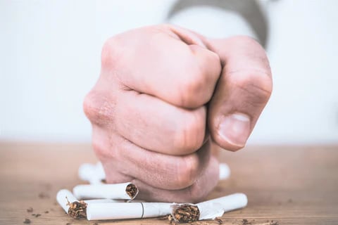 a person holding a cigarette in their hand