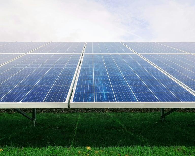Photovoltaic solar panels installed on a green field for renewable energy generation.