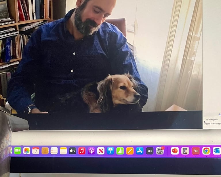 Therapist psychologist sitting on chair with small dog on his lap