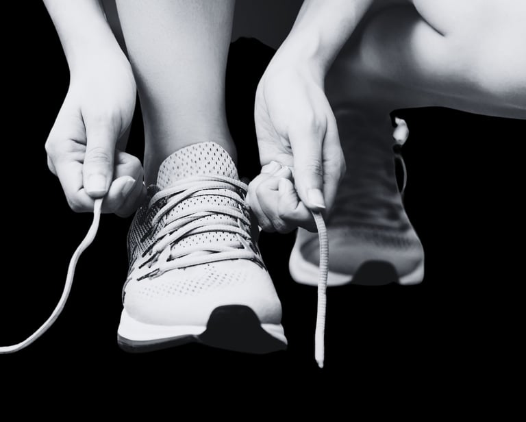 Personne attachant ses lacets, symbole de reprise du sport et de motivation, dans le cadre d’un coaching remise en forme par