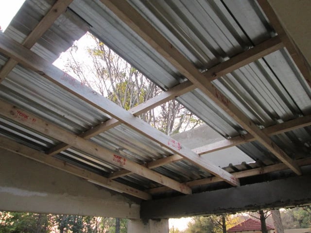 Metal sheet installation over compliant timber purlins