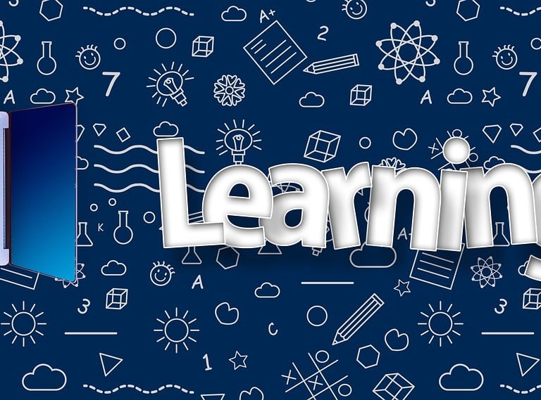 a man sitting at a laptop computer with a laptop on the desk and a laptop