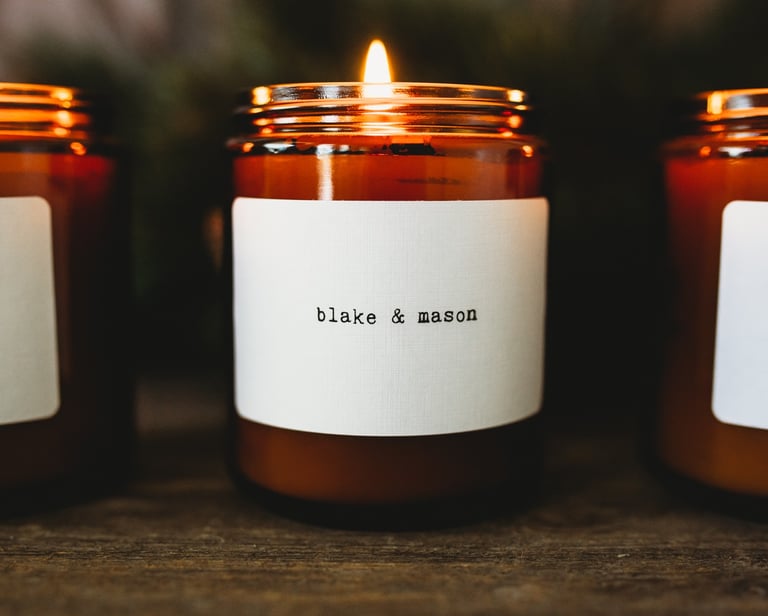 three candles with labels on them are sitting on a table